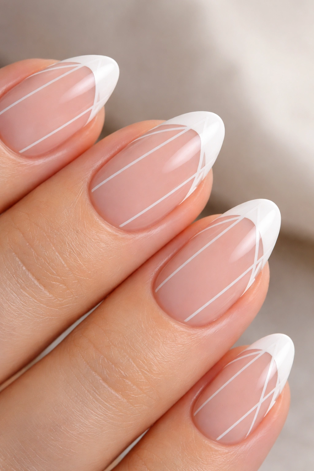 Close-up of a short almond nail with geometric lines on the white tip