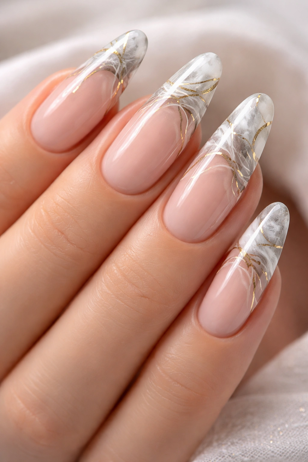 Close-up of long oval nails with marble tips and abstract nail art