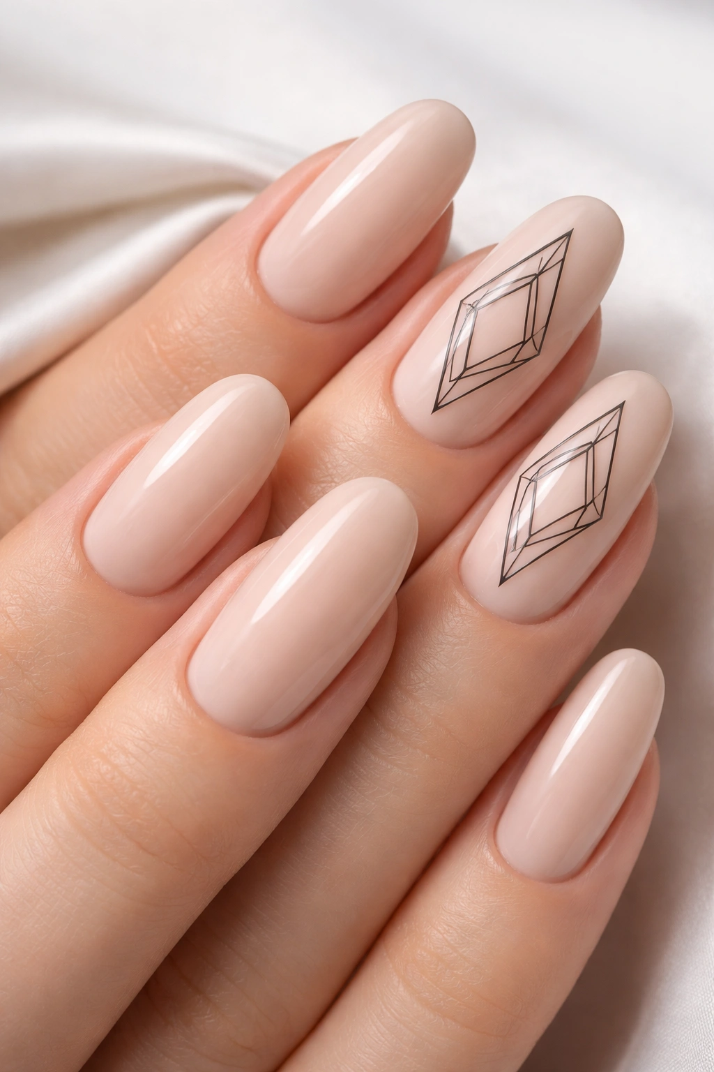 Close-up of nude nails with delicate black diamond outlines on accent nails.