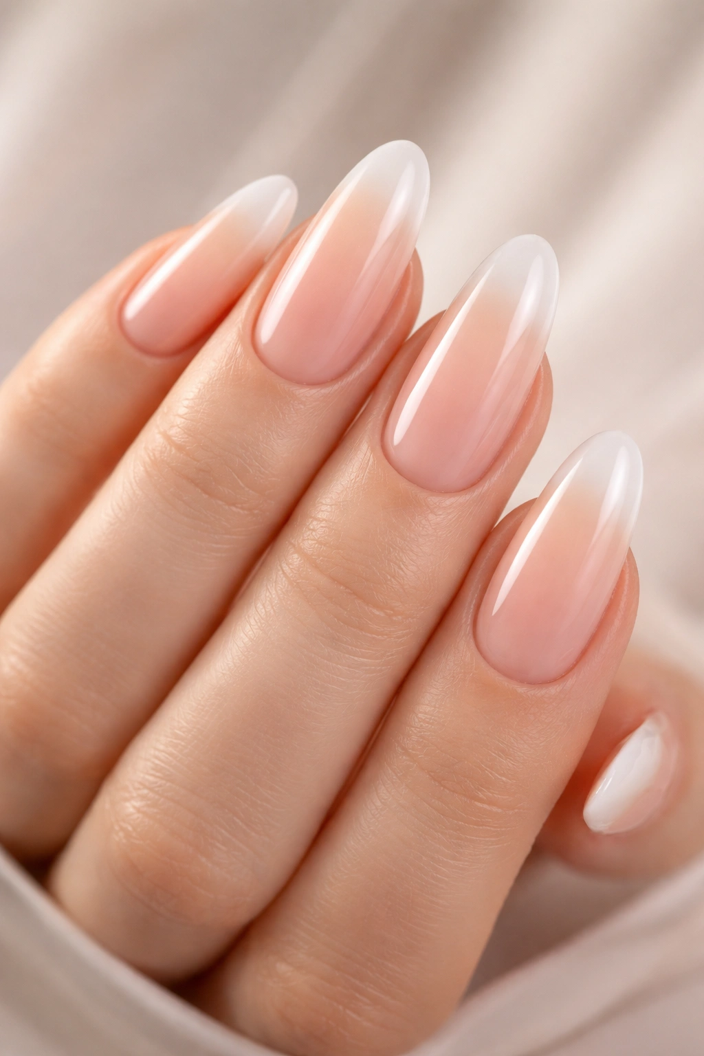 Close-up of long oval nails with a seamless nude gradient French tip