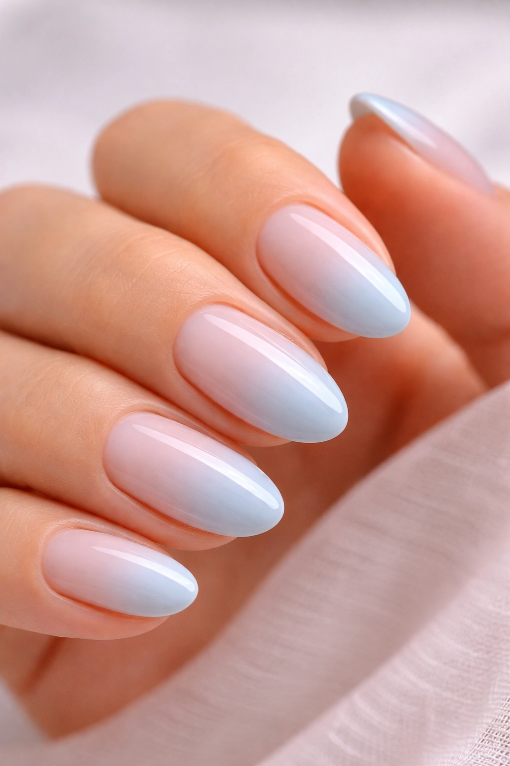 Close-up of light blue ombre French fade on short almond nails