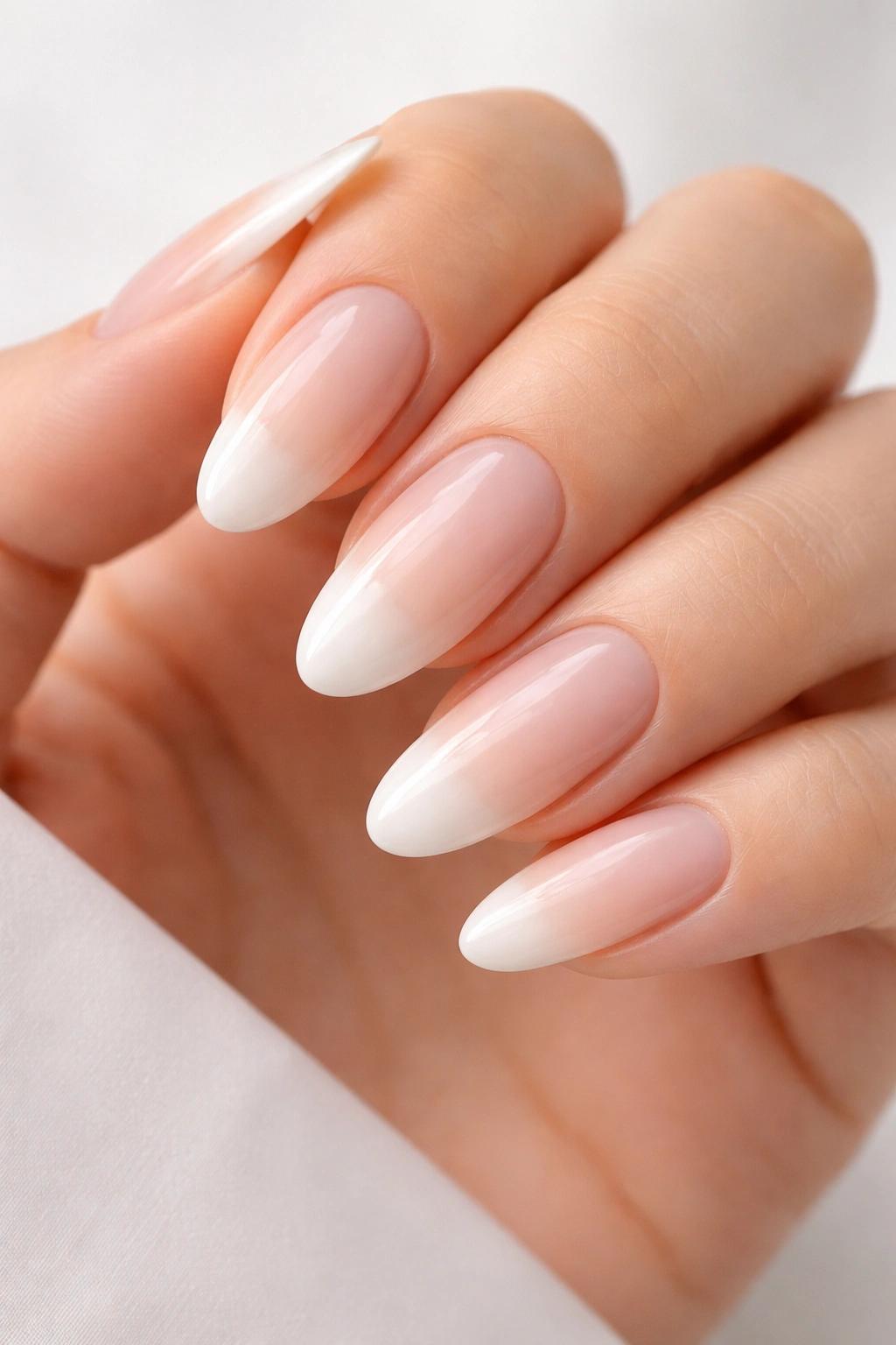Oval nails with soft off-white tips and visible natural nail bed for minimalist French-inspired look