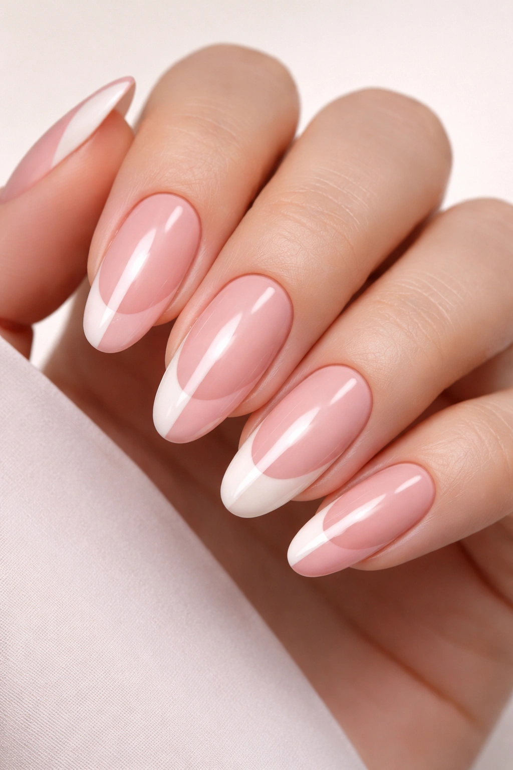 Close-up of long oval nails with a vertical nude and blush split French tip