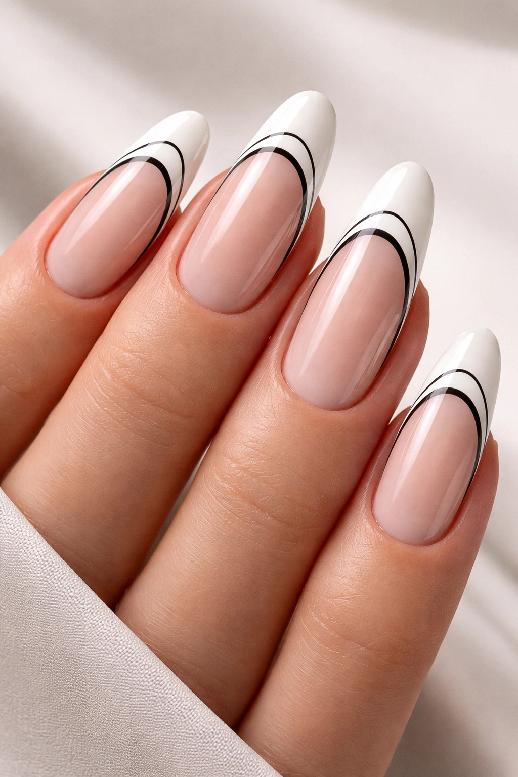 Close-up of long oval nails with white tips and fine black line details