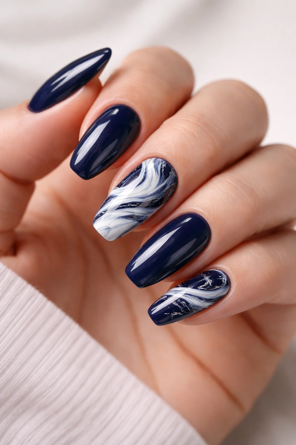 Navy nails with white marble accents on accent nails