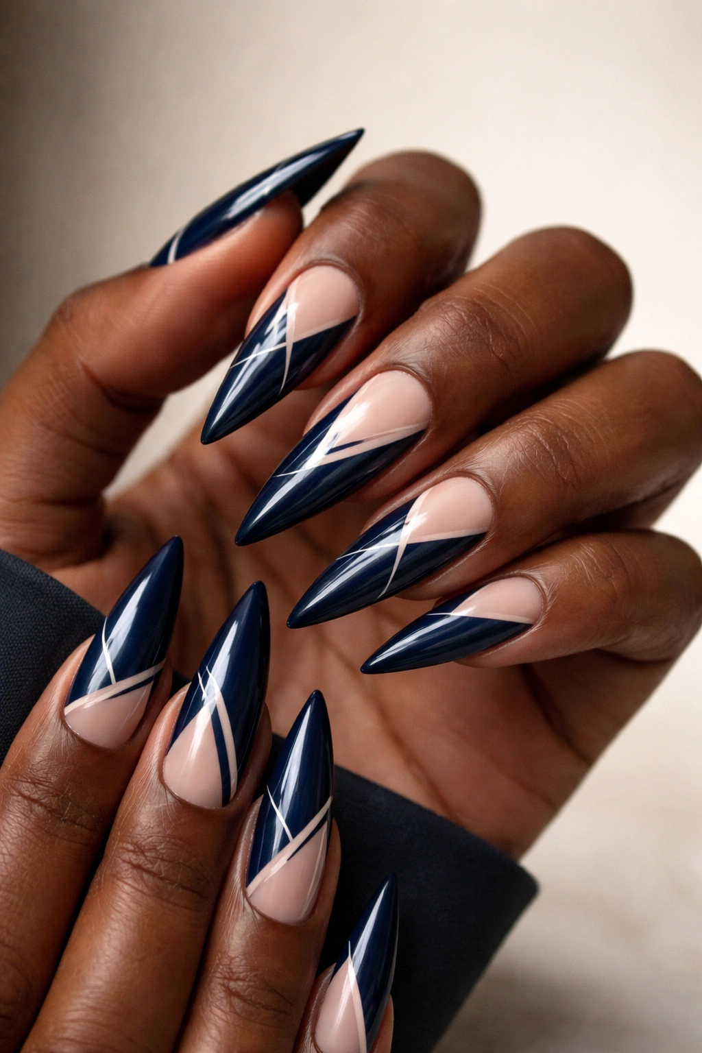 Navy blue stiletto nails with negative space design.