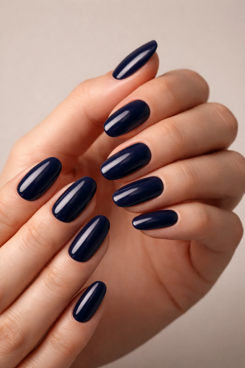 Close-up of hands with deep navy blue nails