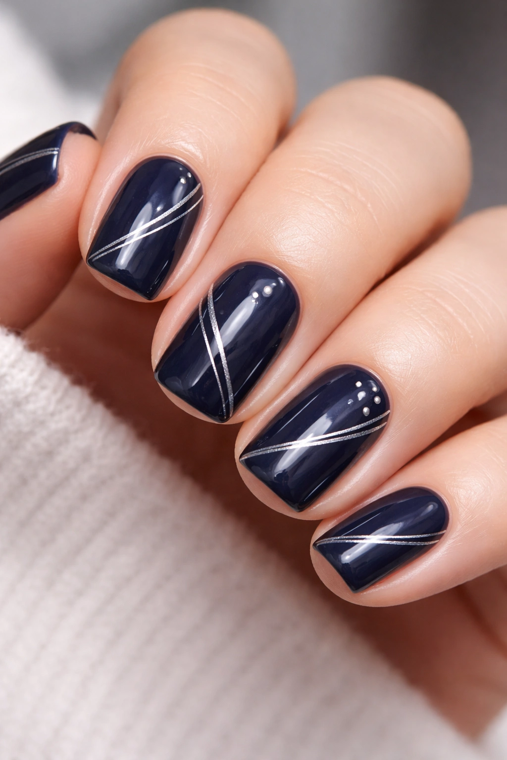Close-up of navy nails with metallic silver accents