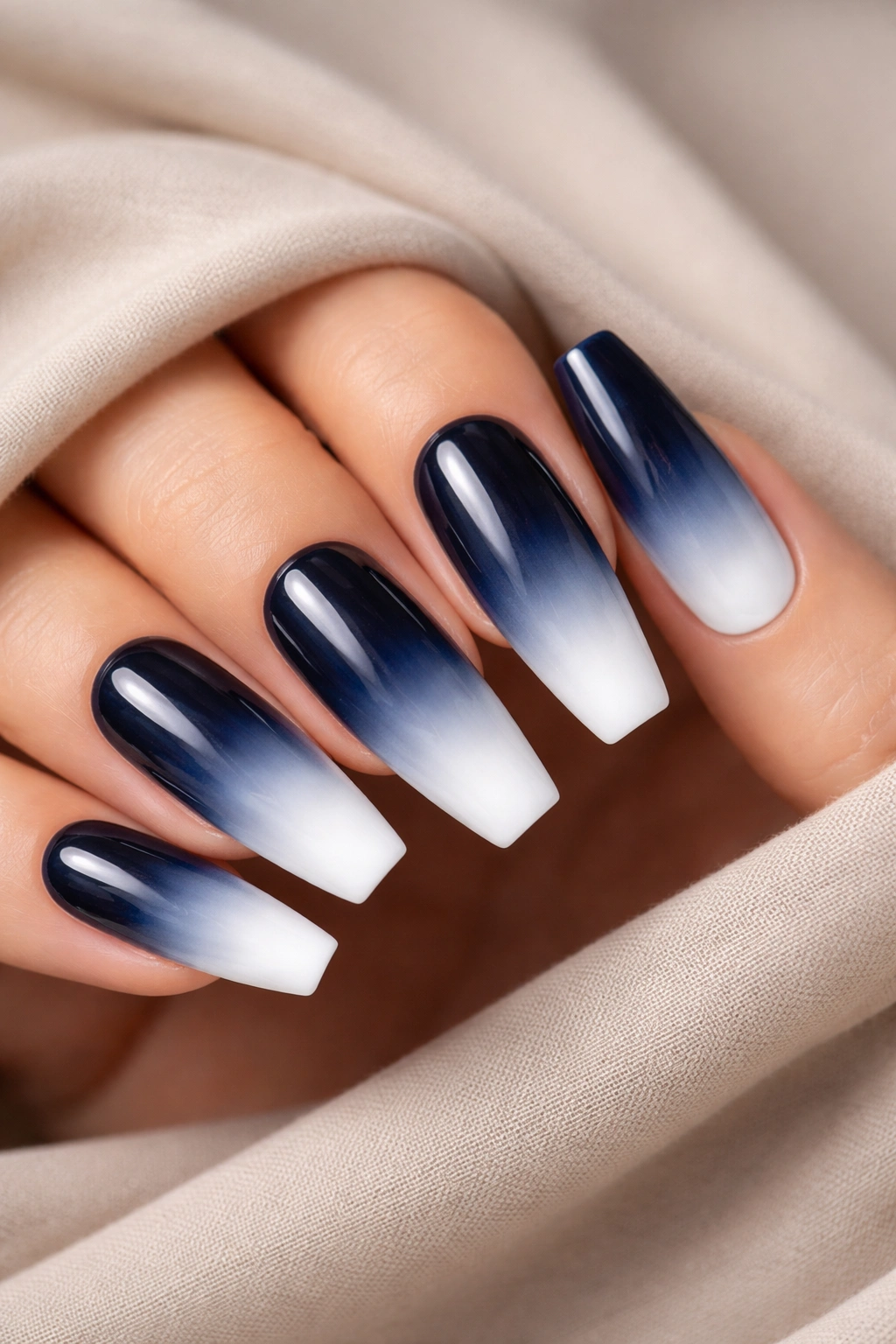 Close-up of navy blue coffin nails with white ombré tips