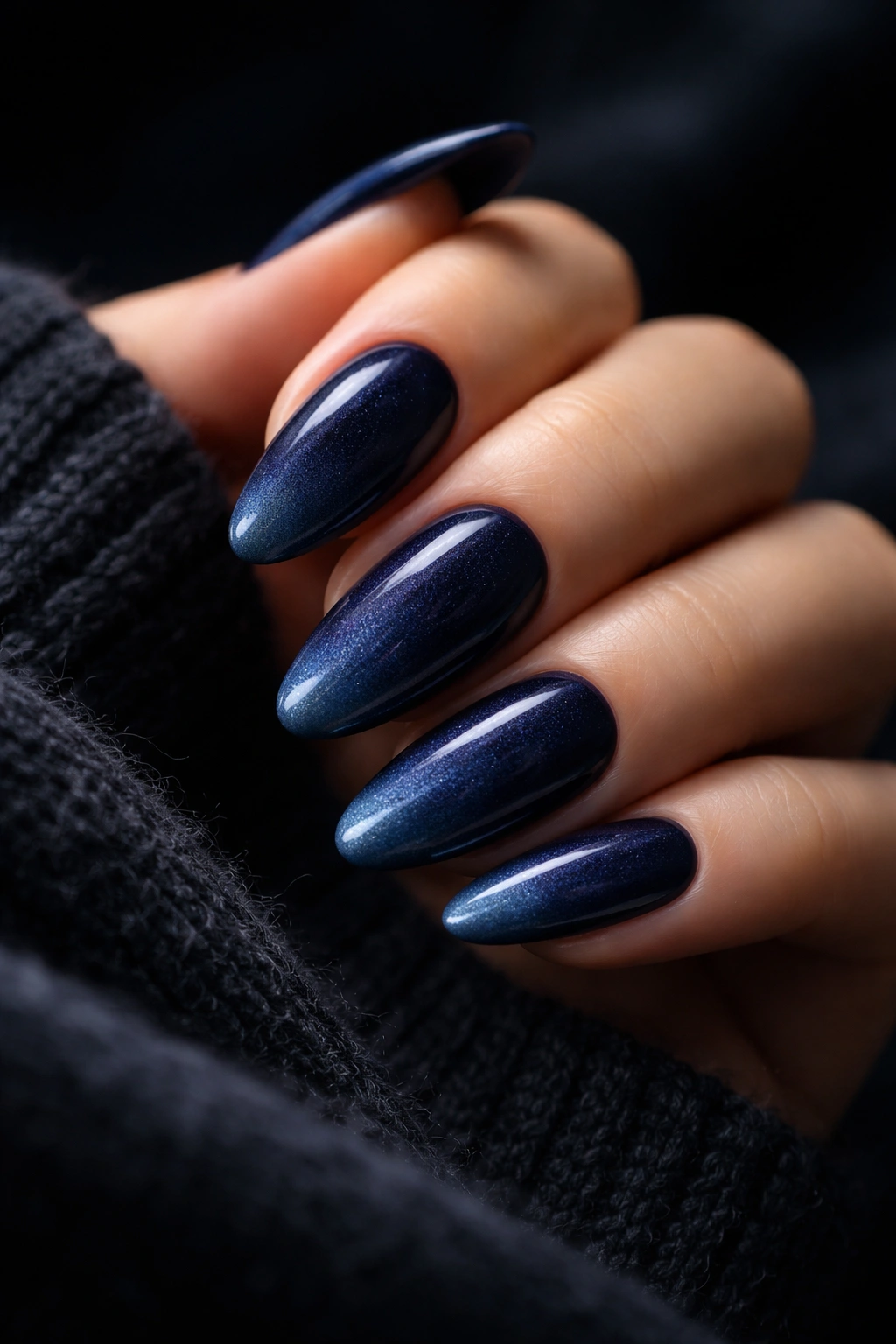 Nails painted in a gradient from navy to midnight blue