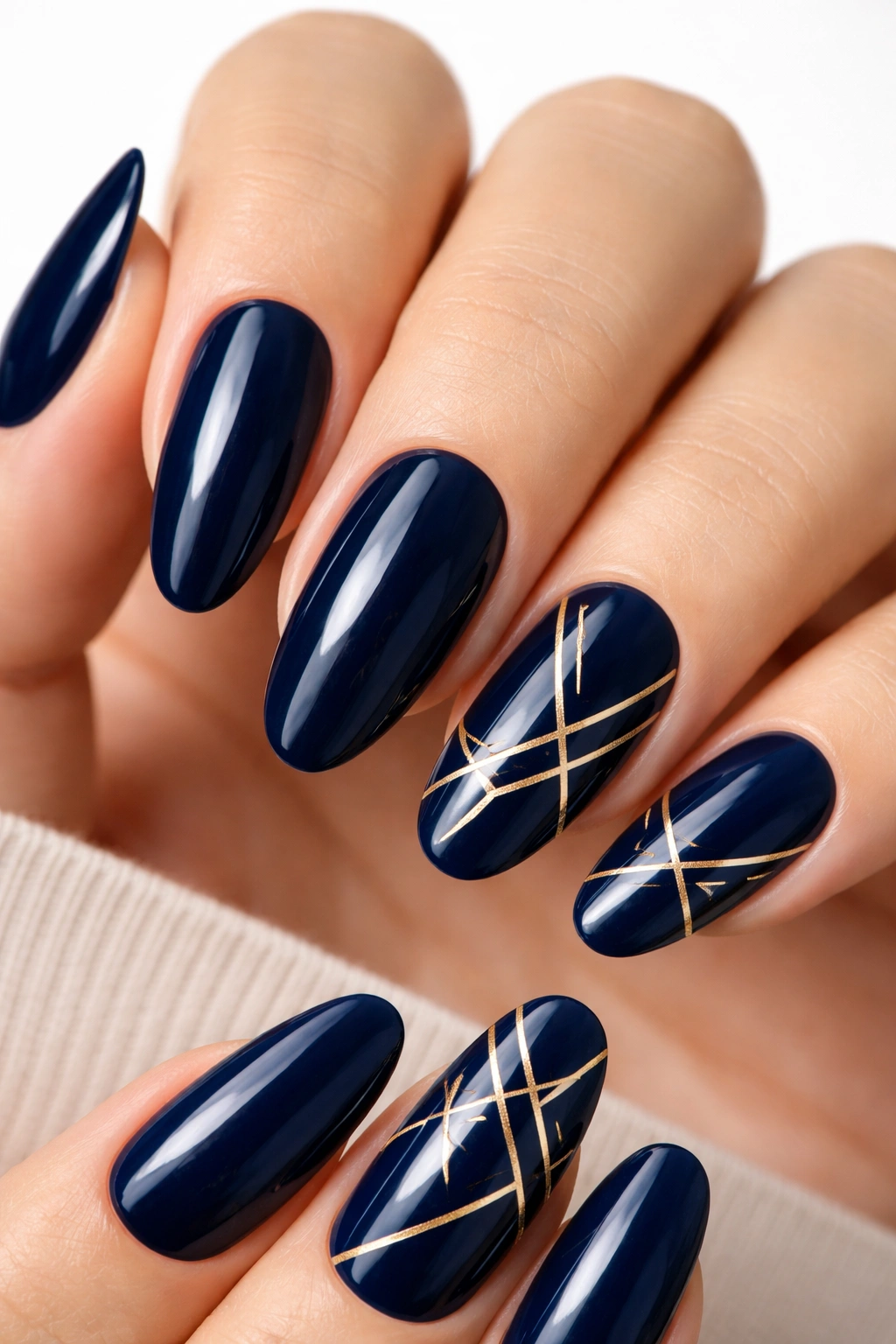 Navy nails with gold geometric accents on accent nails