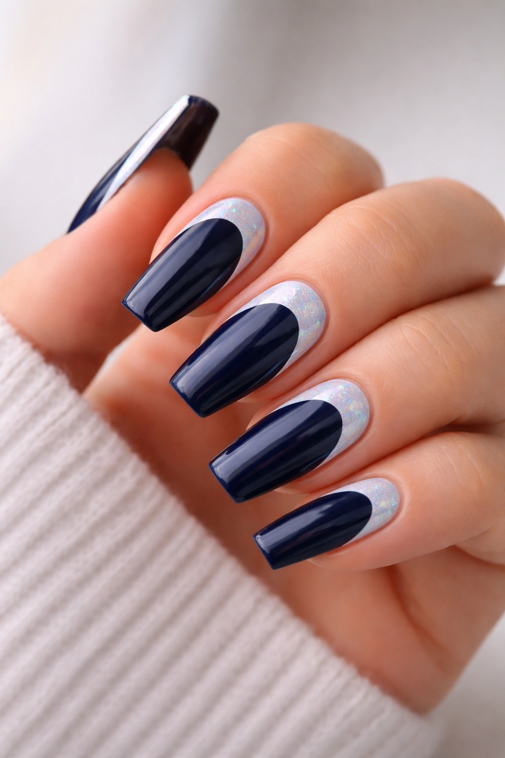 Navy nails with holographic white reverse French tips on coffin nails.