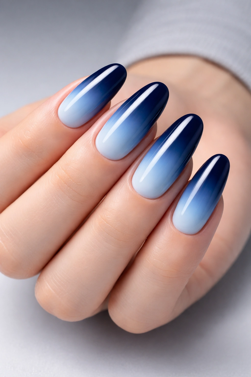 Long oval nails with navy to light blue ombre and glossy shine