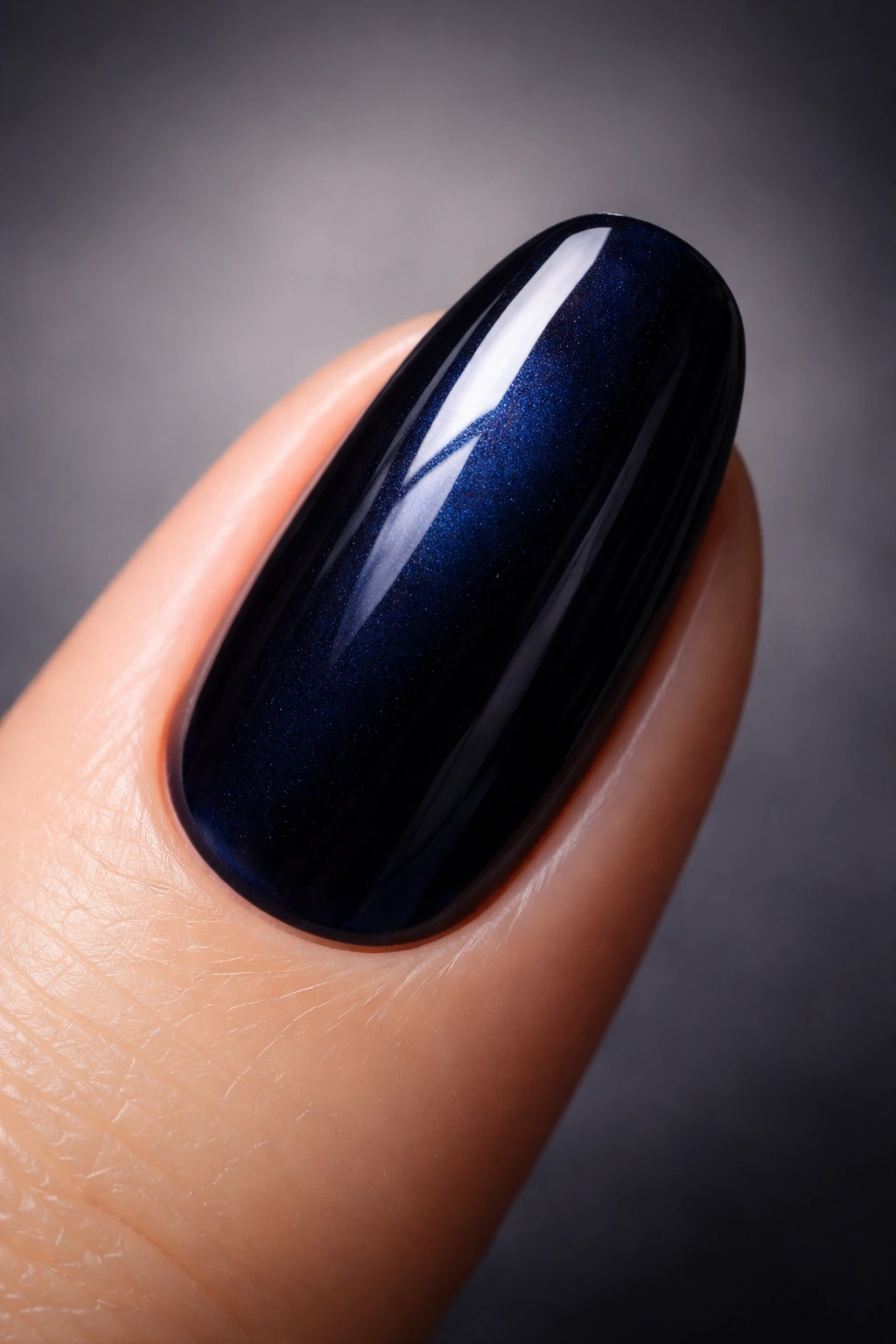 Close-up of a fingernail in midnight navy blue polish showing depth