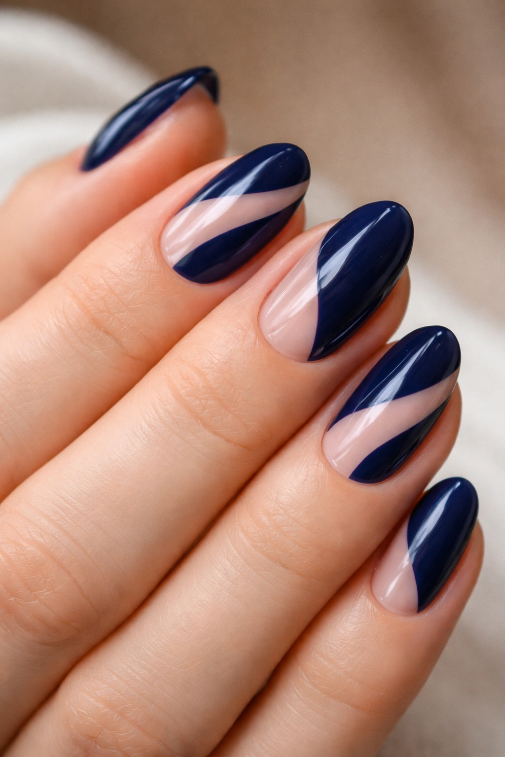 Navy nails showing sheer negative space with diagonal cutouts on almond nails.