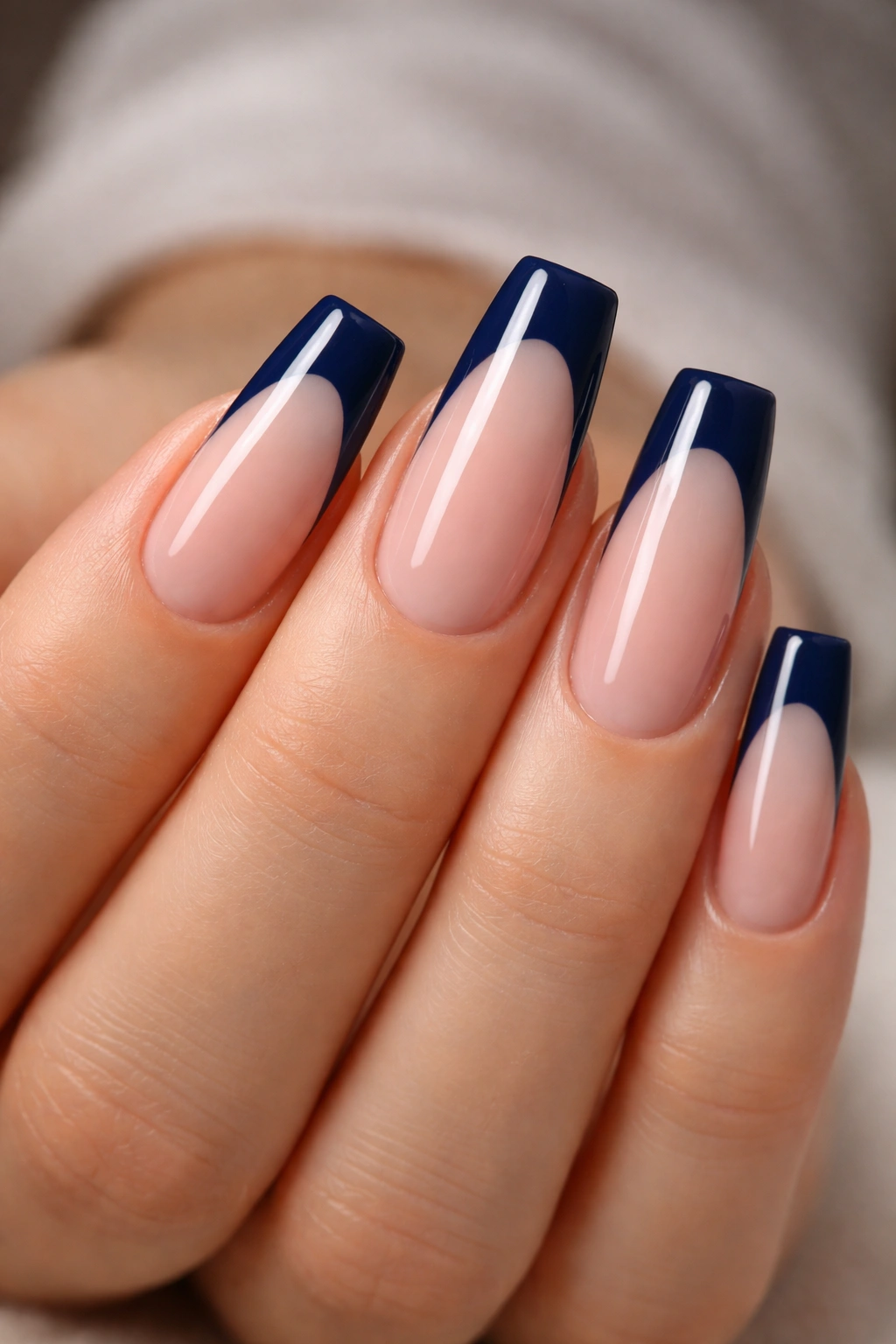 Navy French tip with a glossy smile line on a sheer pink ballerina nail