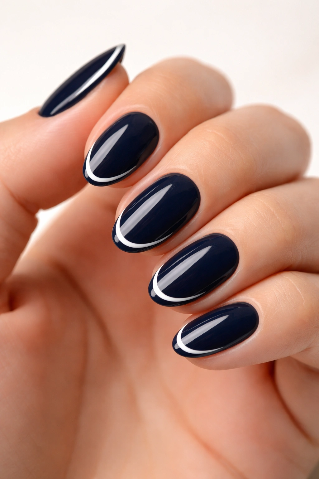Navy nails with a single white line on almond nails