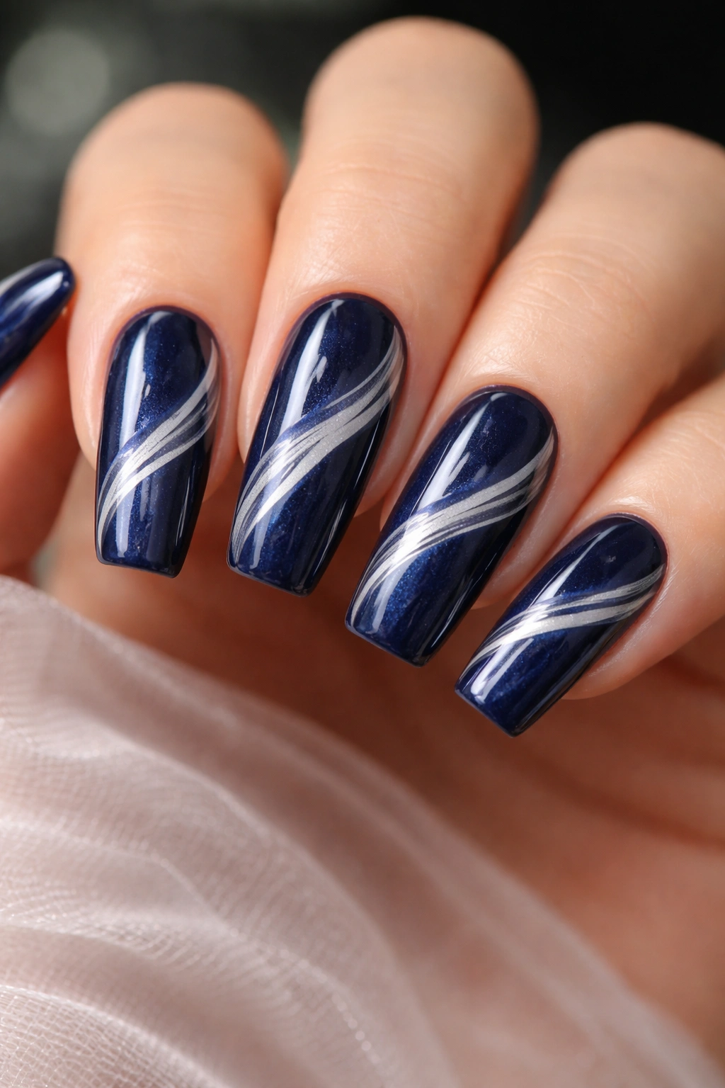 Deep navy nails with white pearl swirl patterns