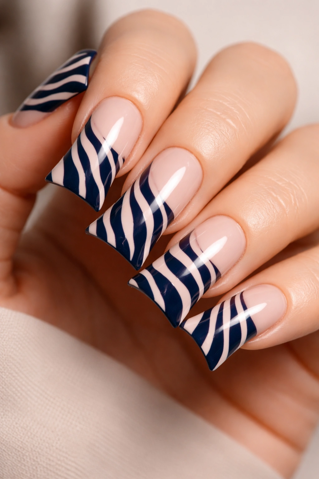 Close-up of navy zebra stripes on nude duck nails for a sophisticated professional manicure