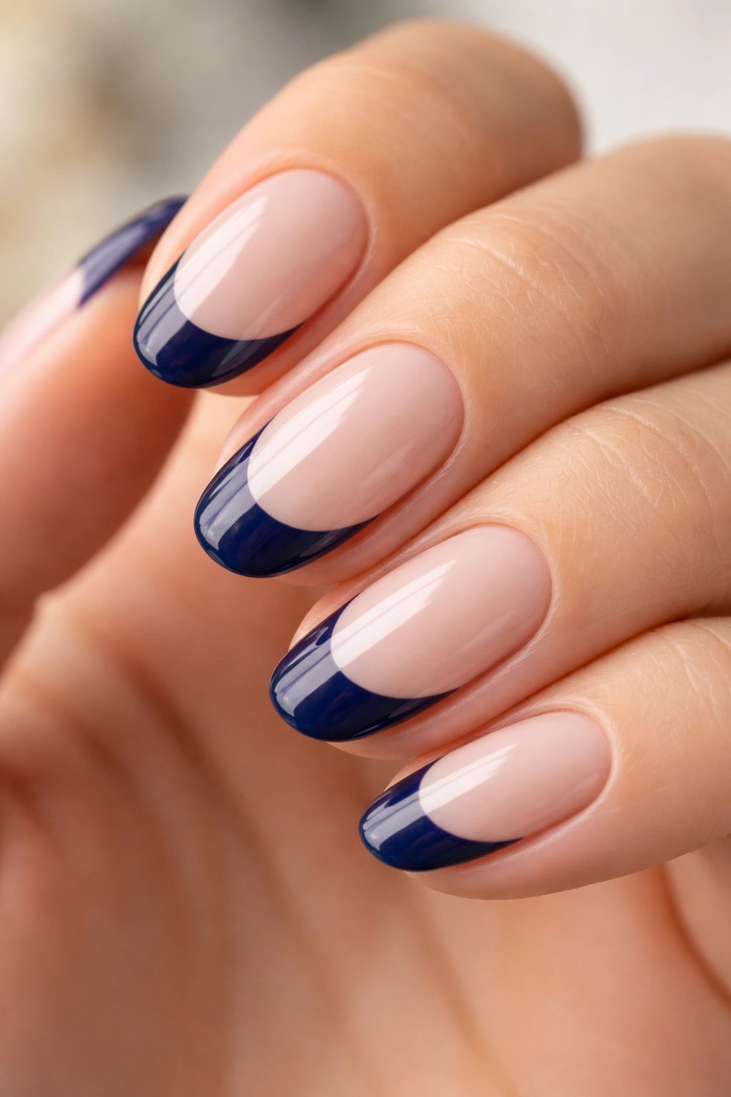 Short almond nail with thick navy tip on sheer pale base