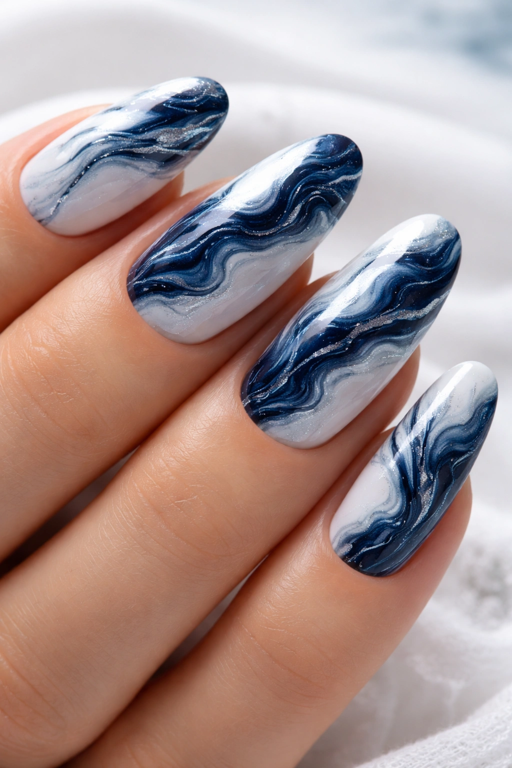 Close-up of navy veined marble nails on white base