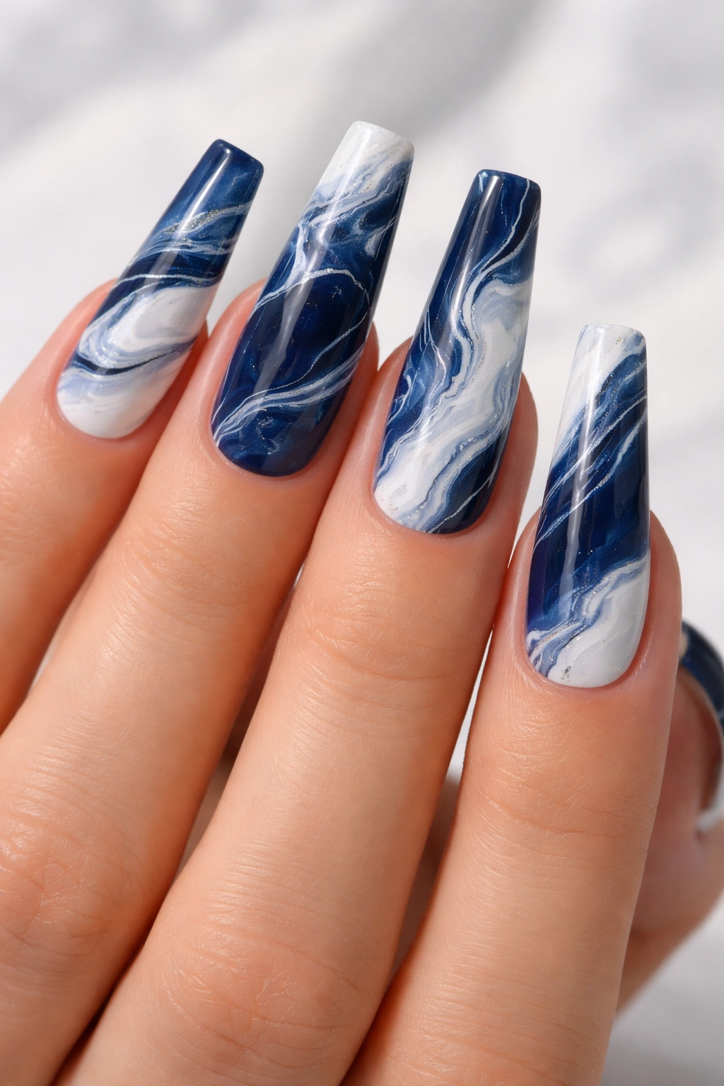 Close-up of navy and white marble coffin nails with flowing veins