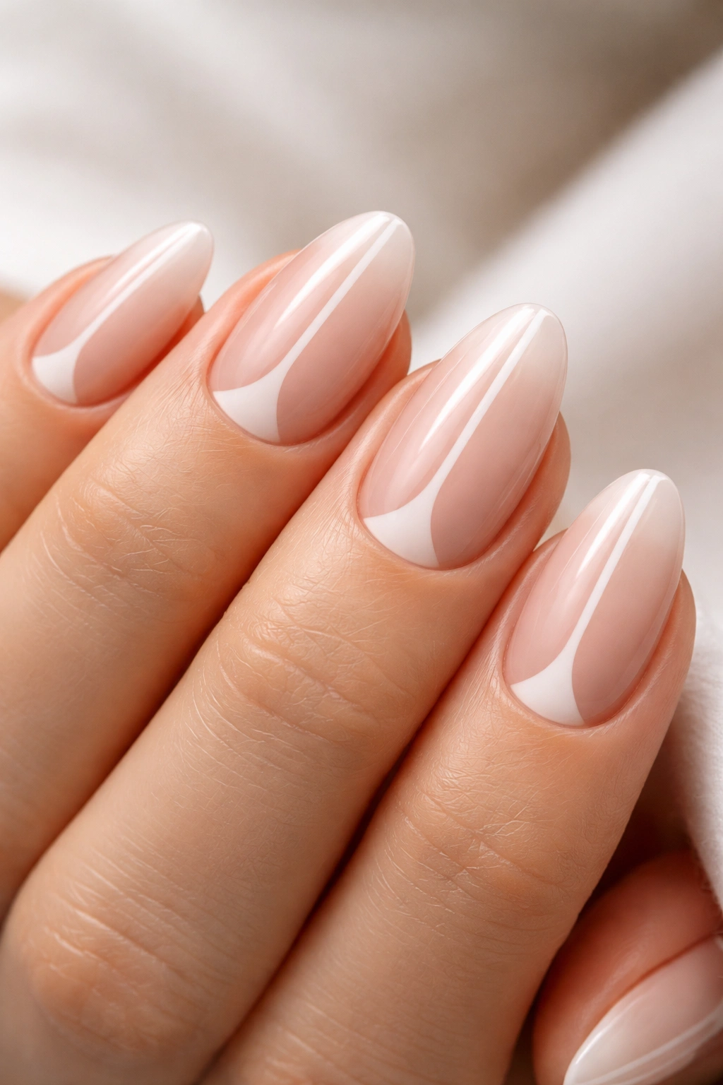 Close-up of short almond nails with negative space crescent and stripe