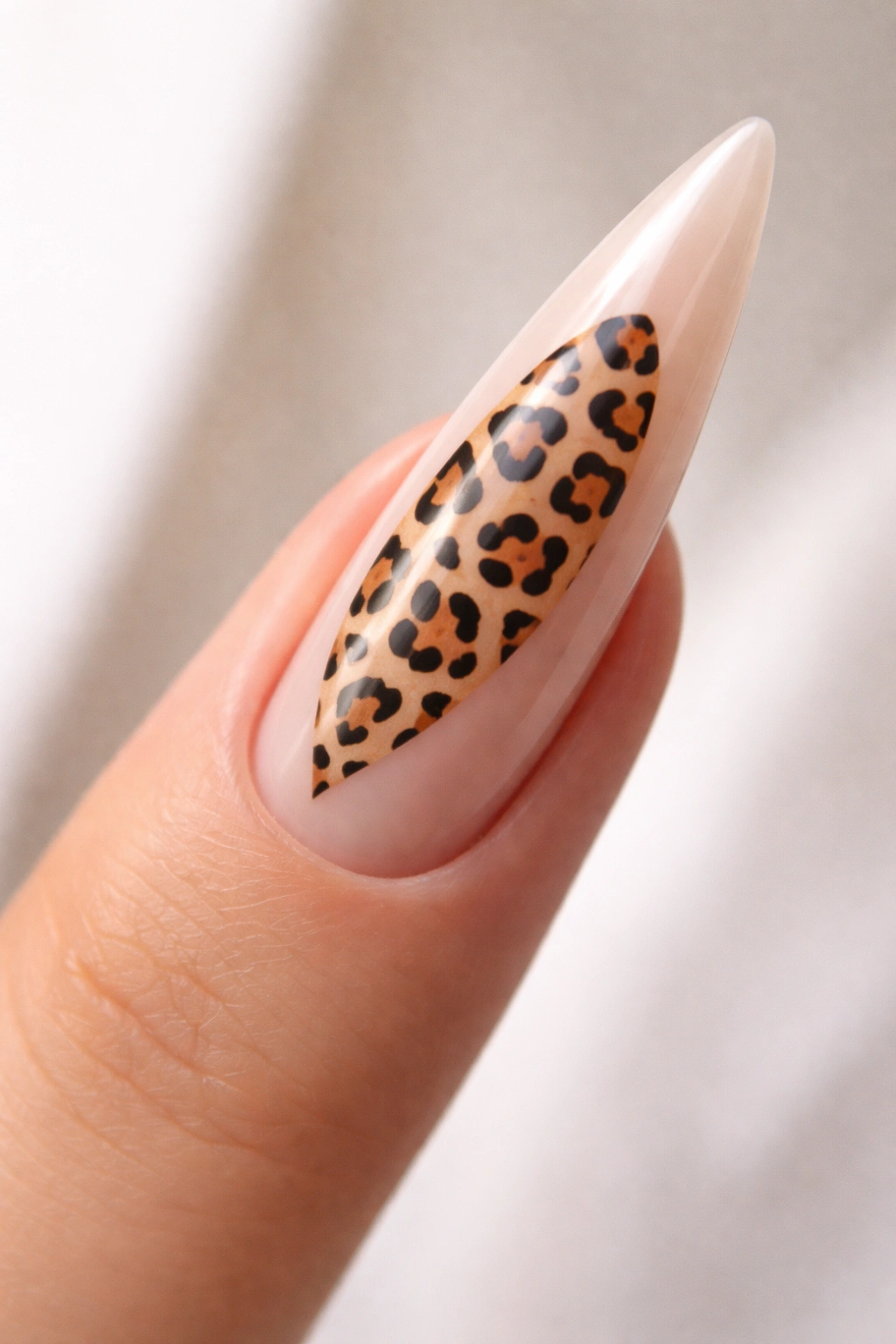Close-up of stiletto nail showing leopard print in a central negative space