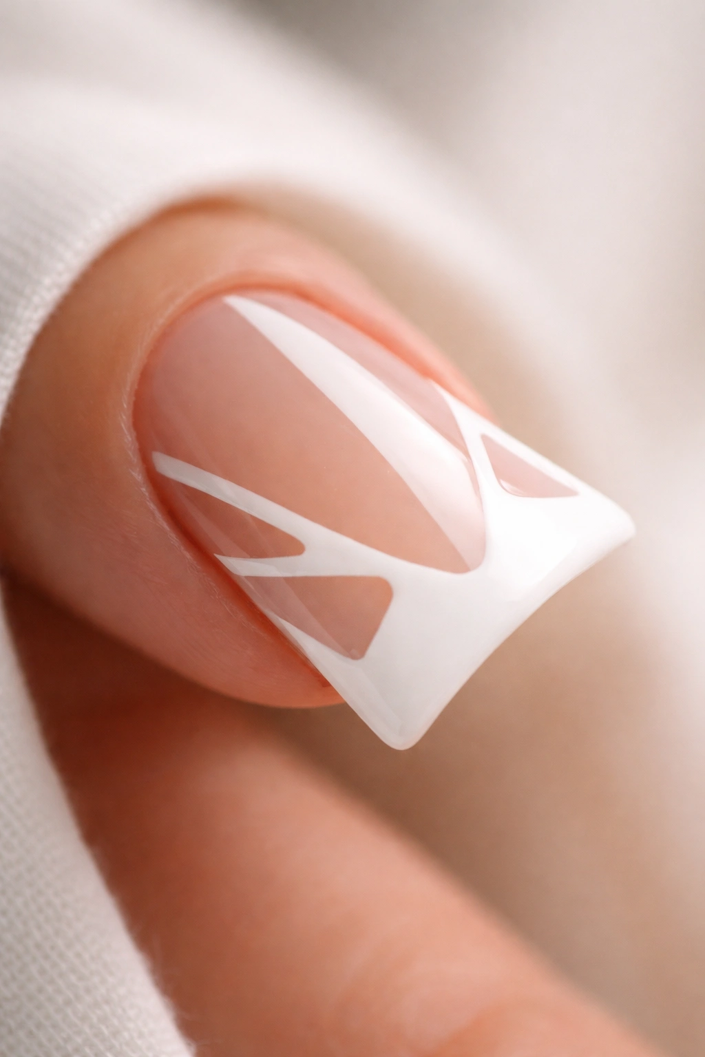 Close-up of negative-space French duck nail with geometric nude cutouts and white tip
