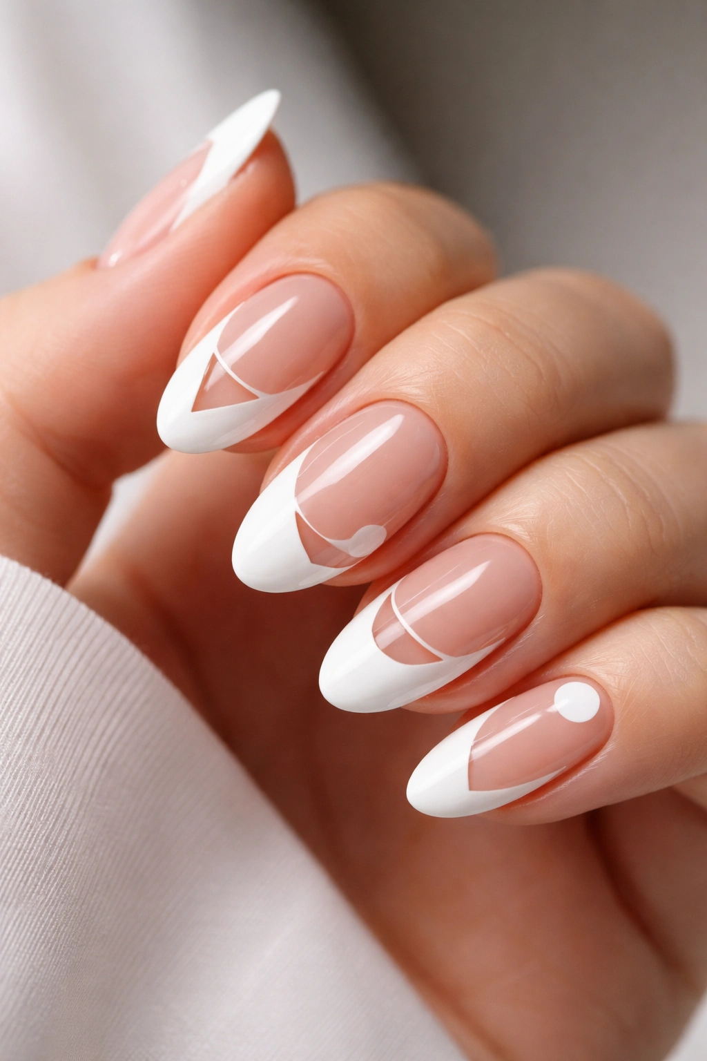 Oval nails featuring negative space French tips with geometric cutouts.