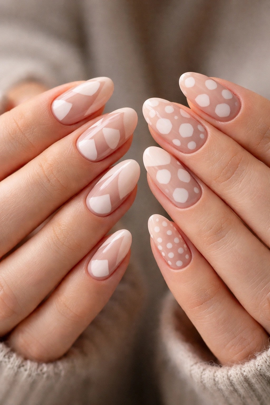 Two hands with negative space geometric nails featuring triangles and circles