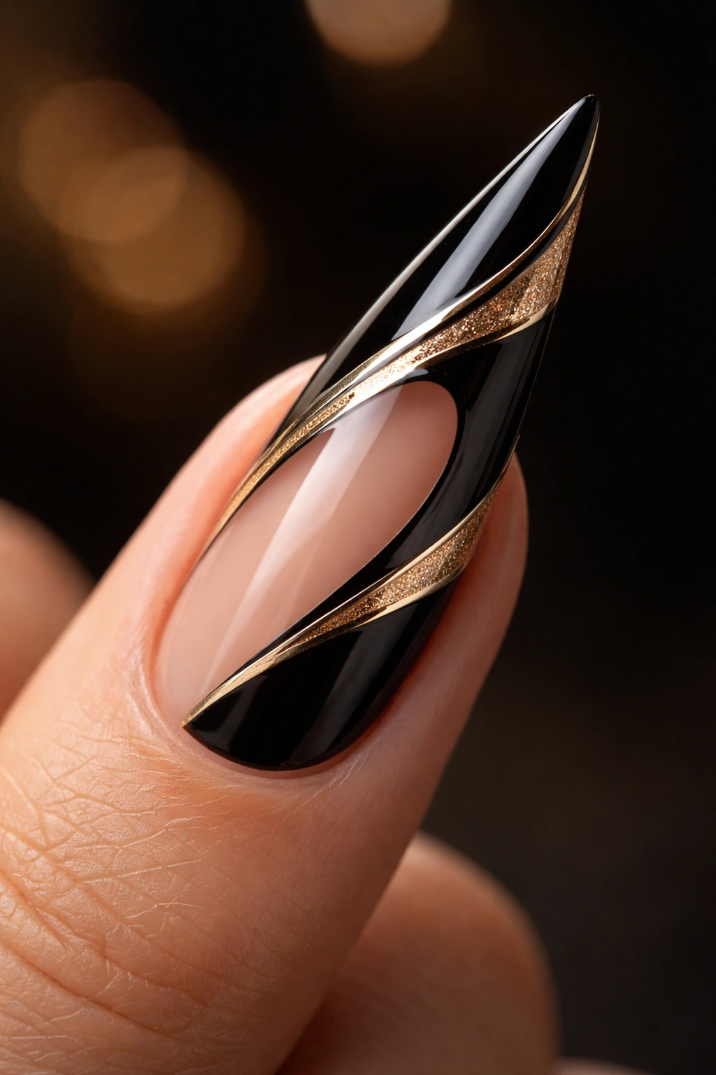 Negative space black and gold stiletto nail close-up