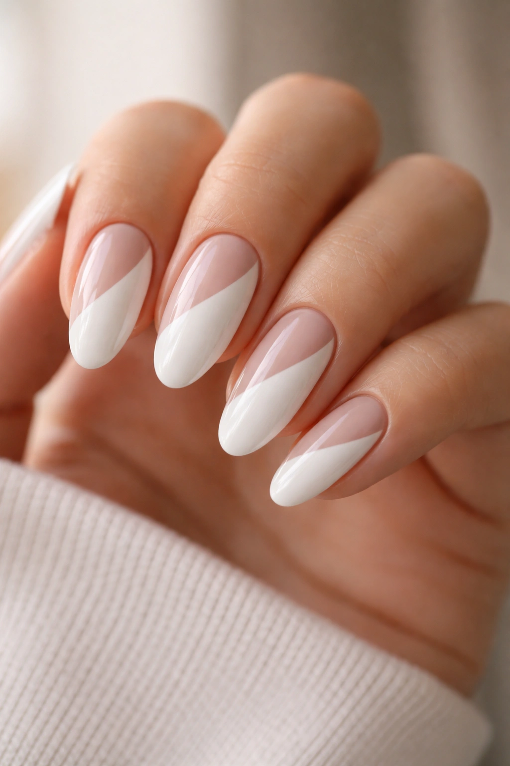 Close-up of white long oval nails with nude negative space design