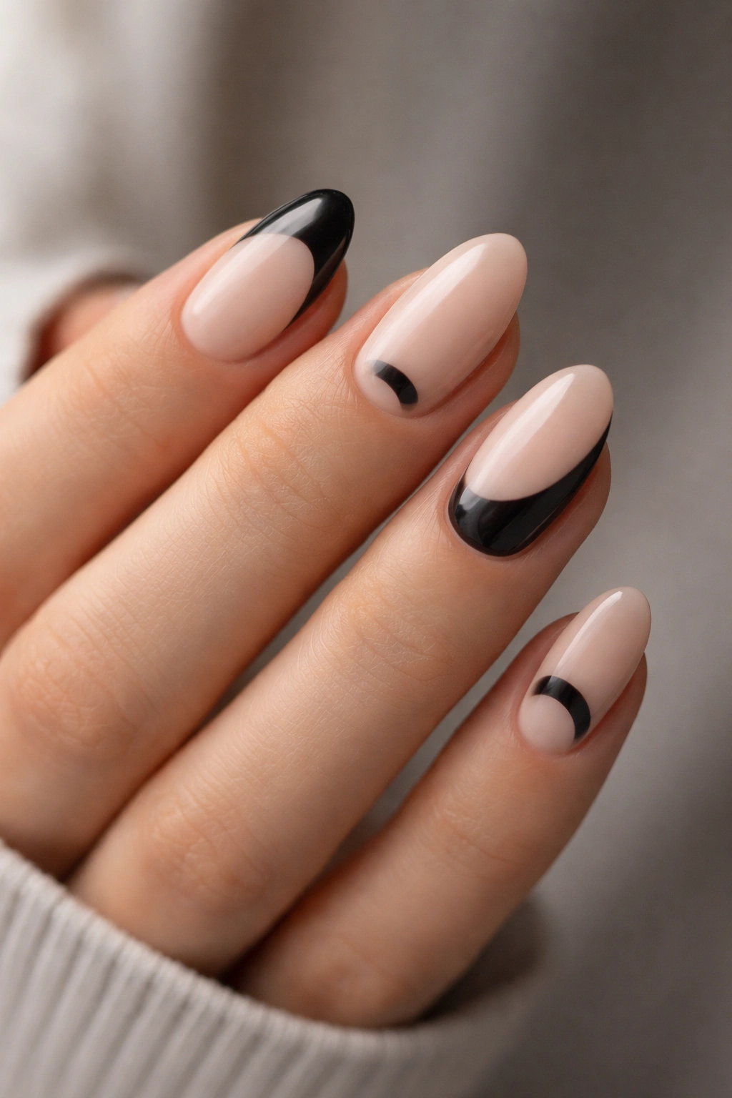 Close-up of short almond nails with cutout negative-space designs and clean edges