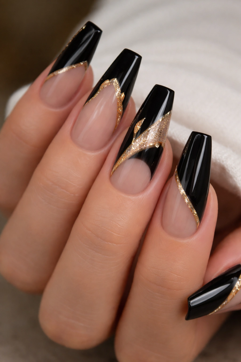 Medium coffin nails featuring black negative space with gold accents