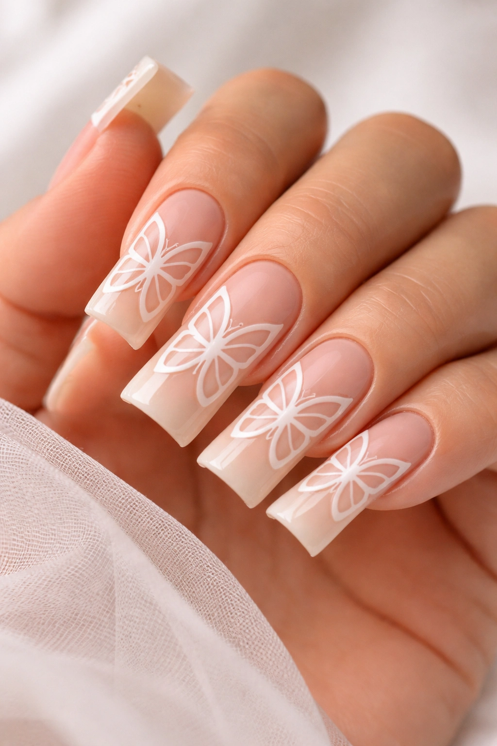 Nude duck nails showing a butterfly outline through negative space