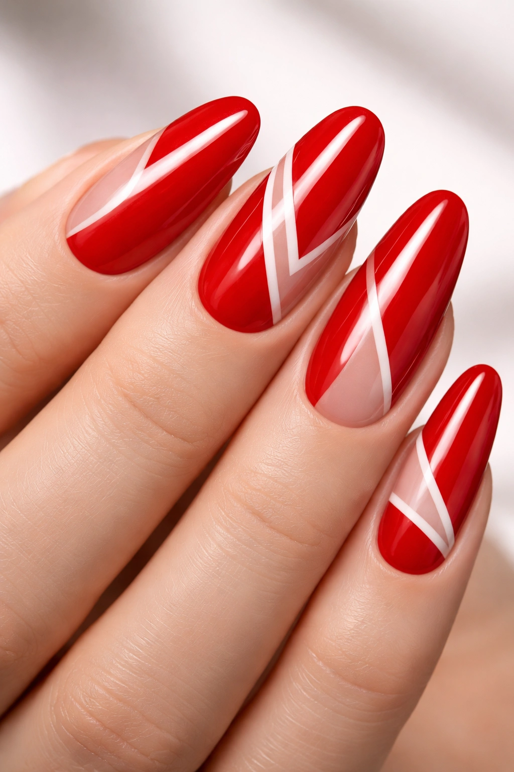 Close-up of red oval nail with white negative-space geometric shapes