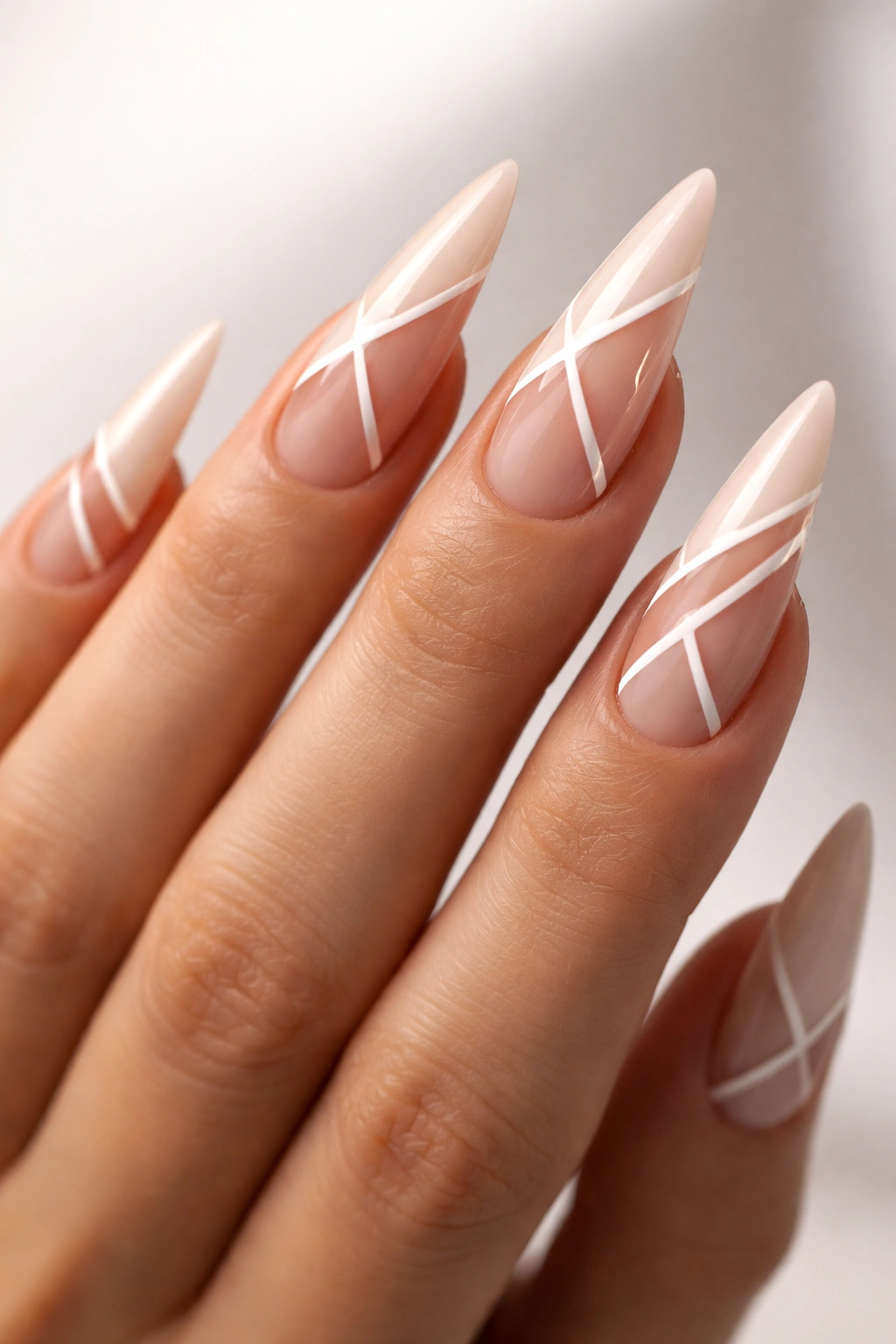 Nude stiletto nails with geometric negative-space cutouts.