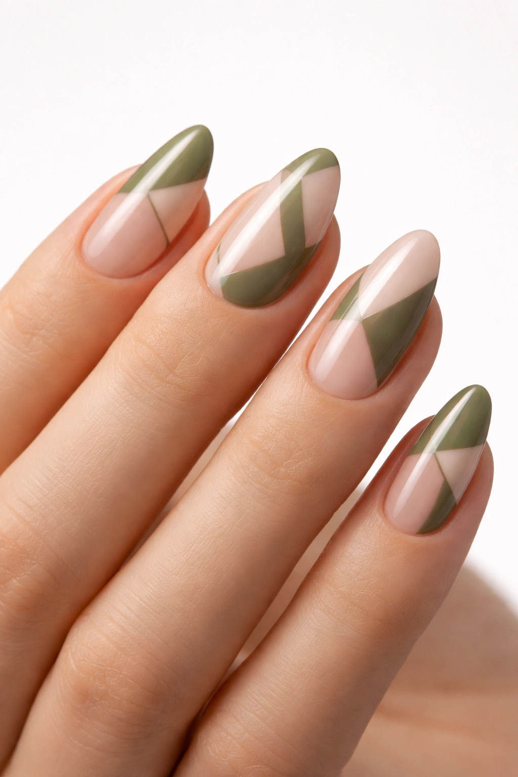 Negative space geometric nails in green and nude with bare nail areas