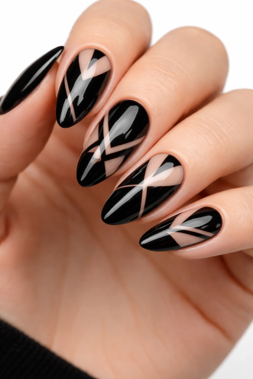 Close-up of black nails with negative-space geometric designs showing natural nail