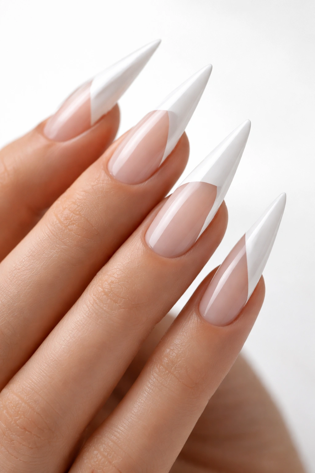 Close-up of minimalist white stiletto nails with negative space design