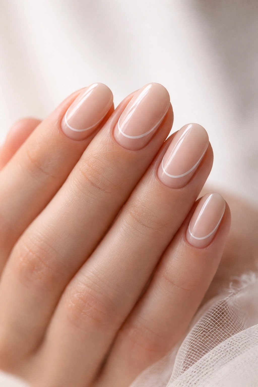 Close-up of short oval nails featuring minimalist negative space design