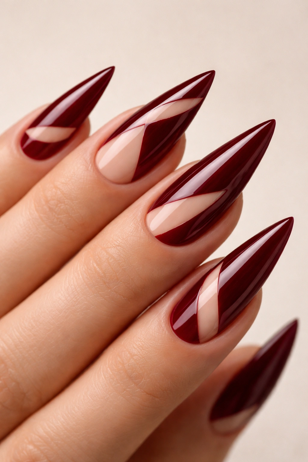 Dark red nails with geometric negative-space cutouts.
