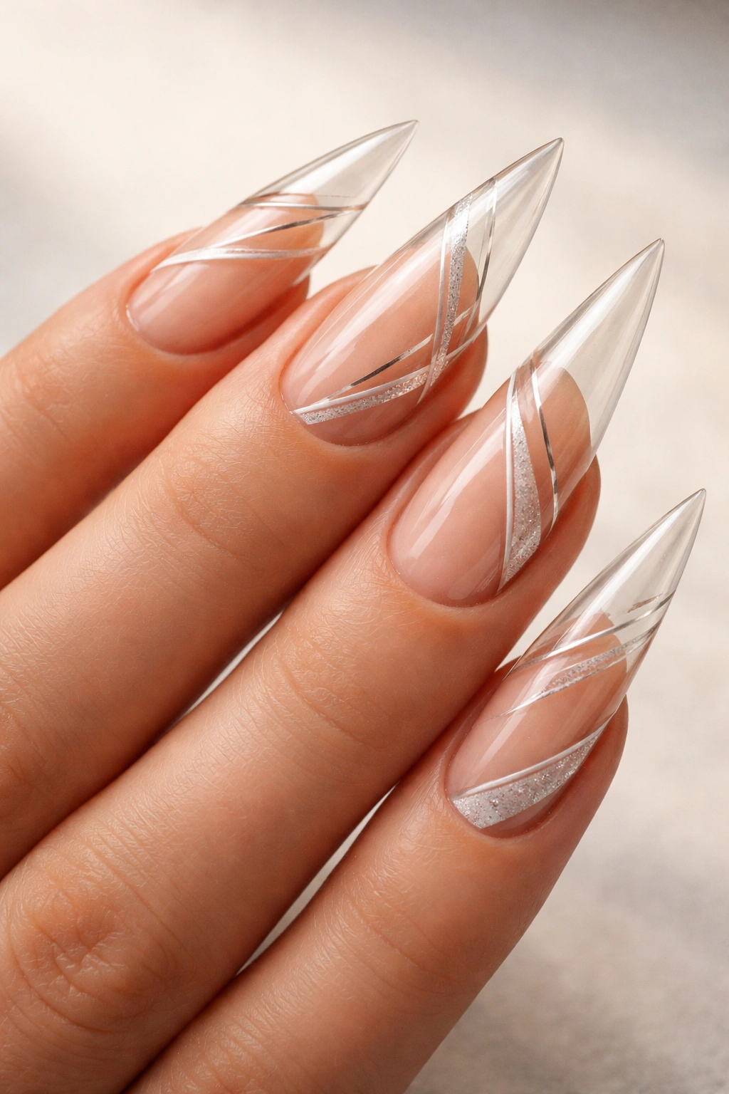 Close-up of clear stiletto nails with geometric negative-space cutouts
