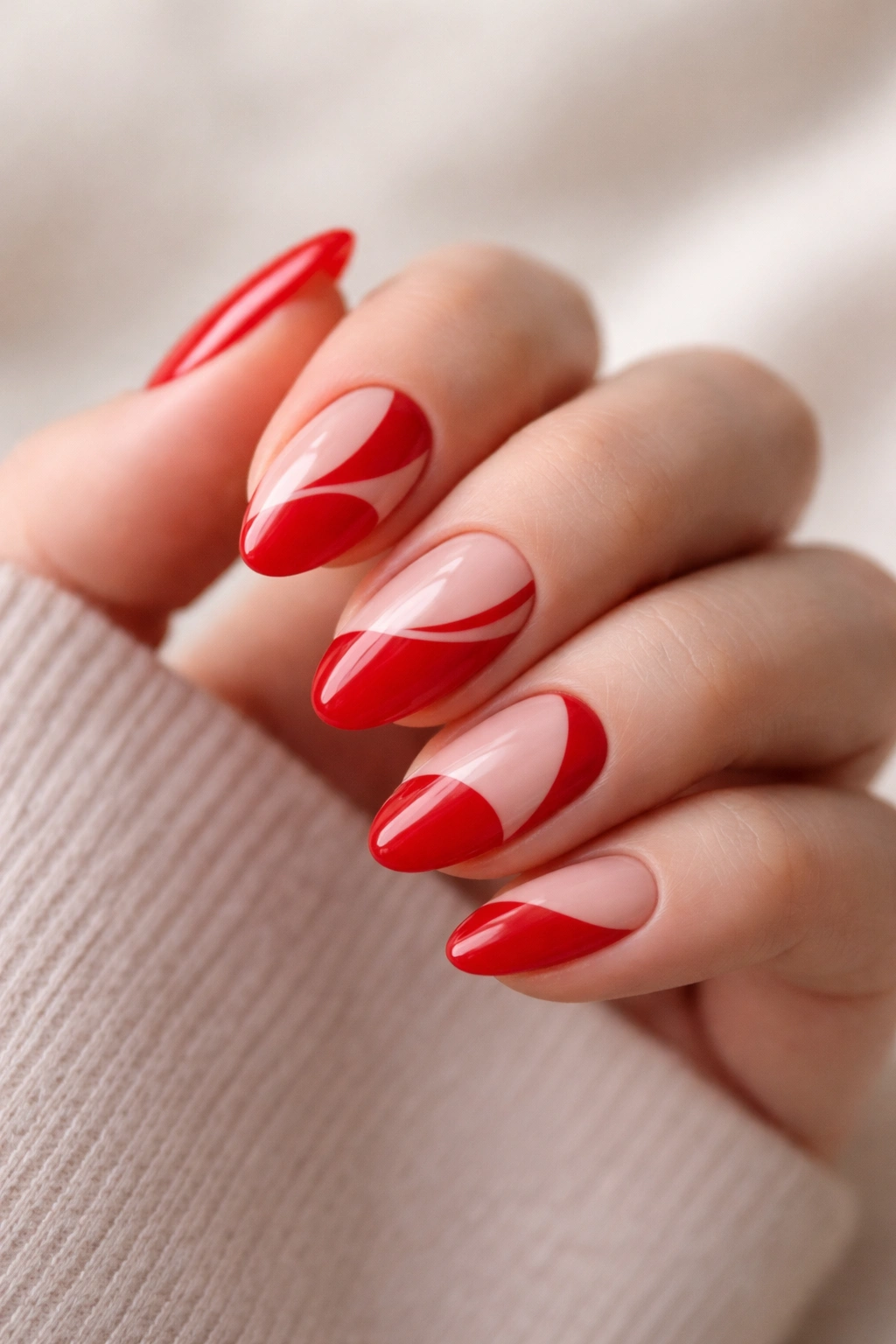 Close-up of red almond nails with negative space design.