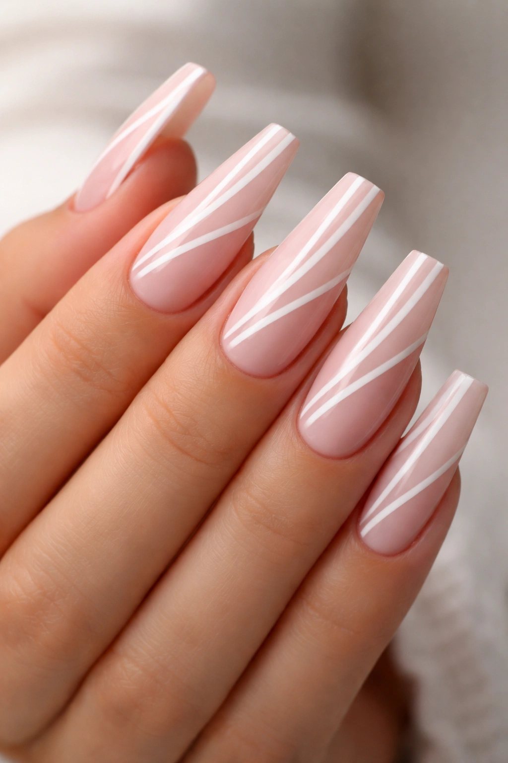 Coffin nails with white negative-space stripes on light pink base