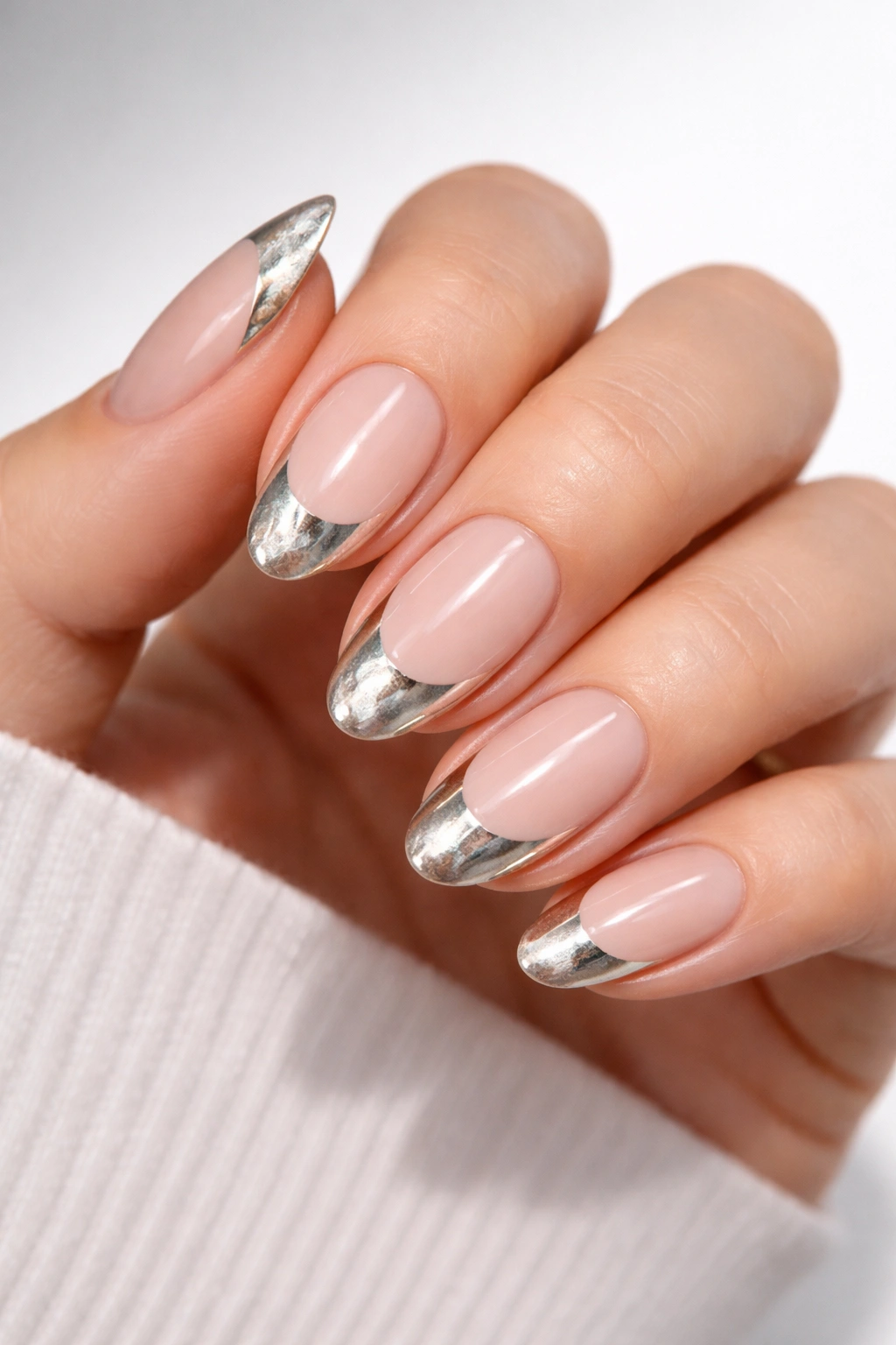 Oval nails with negative-space tips and metallic underlayer visible