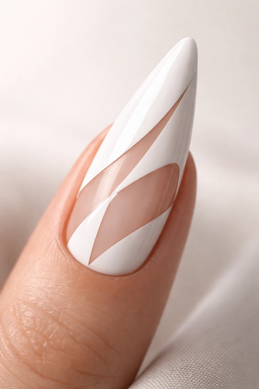 Close-up of a white stiletto nail with a geometric negative-space design