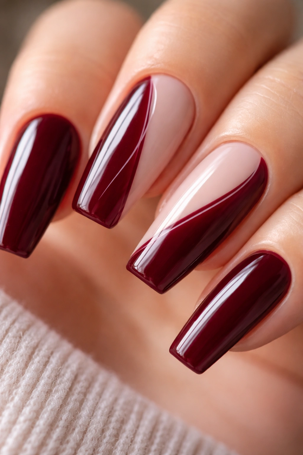 Wine burgundy nail with a negative-space side swirl