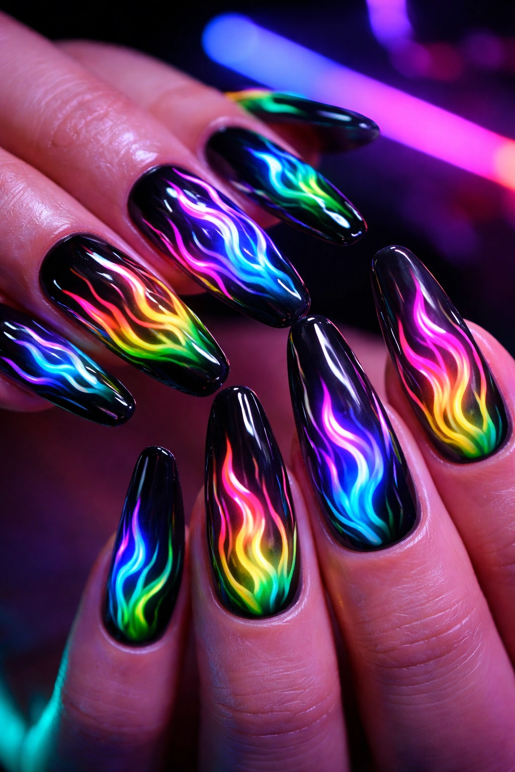 Close-up of nails with neon rainbow flame design under UV light